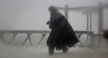 Movie still from “Quintet” (1979), directed by Robert Altman – A man walking in the snow on a cloudy day; Wide shot, Low angle