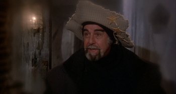 Movie still from “Quintet” (1979), directed by Robert Altman – A man with a beard and a cowboy hat; Close Up shot, Over the shoulder angle