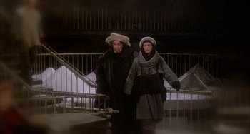Movie still from “Quintet” (1979), directed by Robert Altman – A man and a woman standing next to a railing; Wide shot, High angle