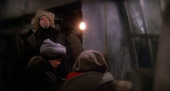 Movie still from “Quintet” (1979), directed by Robert Altman – A group of people sitting in a room; Medium shot, High angle