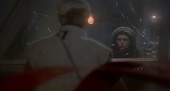 Movie still from “Quintet” (1979), directed by Robert Altman – A man looking in the mirror in front of a woman; Close Up shot, Over the shoulder angle