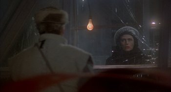 Movie still from “Quintet” (1979), directed by Robert Altman – A woman is looking in the mirror in front of a man; Close Up shot, Over the shoulder angle