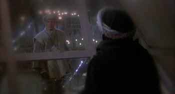 Movie still from “Quintet” (1979), directed by Robert Altman – A man standing in front of a mirror in front of a woman; Medium shot, Over the shoulder angle