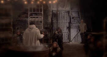 Movie still from “Quintet” (1979), directed by Robert Altman – A group of people standing around in a room; Wide shot, High angle