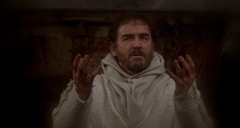 Movie still from “Quintet” (1979), directed by Robert Altman – A man with a beard and a white robe is holding his hands up; Medium shot, Low angle