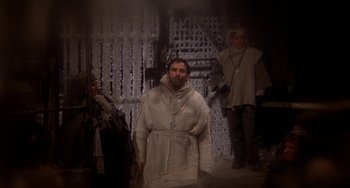 Movie still from “Quintet” (1979), directed by Robert Altman – A man dressed as a monk standing in front of a wall; Medium shot, Low angle