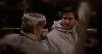 Movie still from “Quintet” (1979), directed by Robert Altman – A man and a woman are talking to each other; Medium shot, Over the shoulder angle