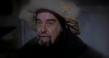 Movie still from “Quintet” (1979), directed by Robert Altman – A man with a beard and a cowboy hat on; Close Up shot, High angle