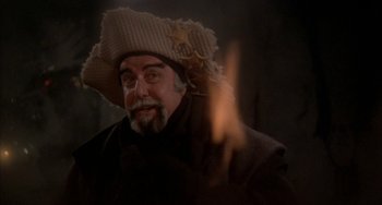 Movie still from “Quintet” (1979), directed by Robert Altman – A man with a beard wearing a cowboy hat; Close Up shot, Over the shoulder angle