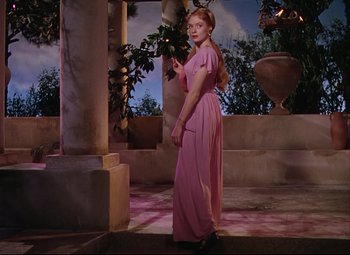 Movie still from “Quo Vadis” (1951), directed by Anthony Mann – A woman in a long pink dress standing on a stage; Wide shot, Low angle