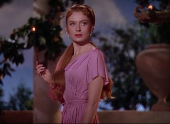 Movie still from “Quo Vadis” (1951), directed by Anthony Mann – A woman in a pink dress holding a lit candle; Medium shot, Low angle