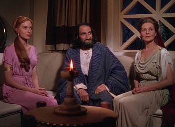 Movie still from “Quo Vadis” (1951), directed by Anthony Mann – A man sitting on a couch next to two women; Medium shot, High angle