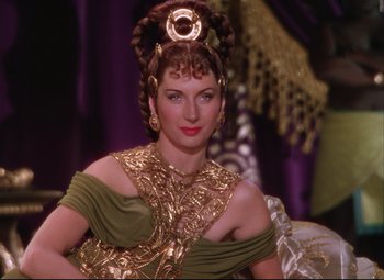 Movie still from “Quo Vadis” (1951), directed by Anthony Mann – A woman in a gold and green dress; Close Up shot, Over the shoulder angle