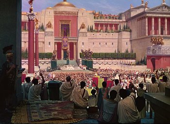 Movie still from “Quo Vadis” (1951), directed by Anthony Mann – A crowd of people sitting in front of a large building; Extreme Wide shot, High angle