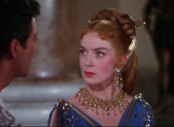 Movie still from “Quo Vadis” (1951), directed by Anthony Mann – A woman with red hair wearing a blue dress and gold jewelry; Close Up shot, Over the shoulder angle