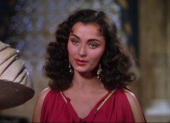 Movie still from “Quo Vadis” (1951), directed by Anthony Mann – A woman in a red dress with long brown hair; Close Up shot, Over the shoulder angle