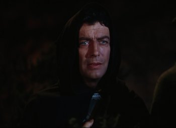 Movie still from “Quo Vadis” (1951), directed by Anthony Mann – A man in a black hooded jacket and a tie; Close Up shot, Over the shoulder angle