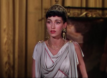 Movie still from “Quo Vadis” (1951), directed by Anthony Mann – A woman wearing a gold crown and a silver dress; Close Up shot, High angle
