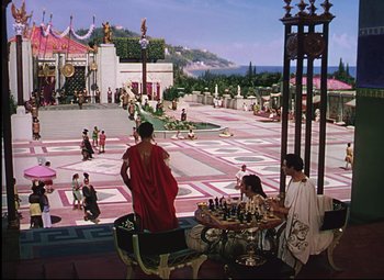Movie still from “Quo Vadis” (1951), directed by Anthony Mann – A group of people sitting around a chess board; Extreme Wide shot, High angle