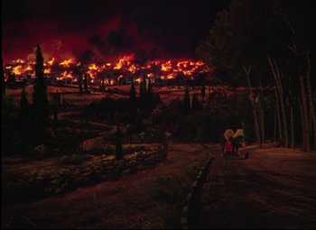Movie still from “Quo Vadis” (1951), directed by Anthony Mann – A large fire is burning in the dark sky; Extreme Wide shot, High angle