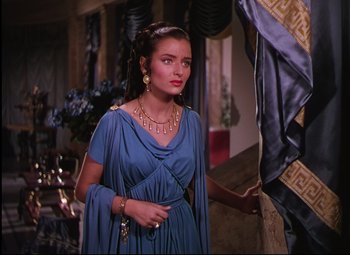 Movie still from “Quo Vadis” (1951), directed by Anthony Mann – A woman in a blue dress standing next to a wall; Medium shot, Over the shoulder angle