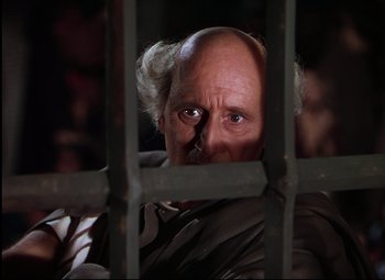Movie still from “Quo Vadis” (1951), directed by Anthony Mann – An old man looking through the bars of a jail cell; Close Up shot, Low angle