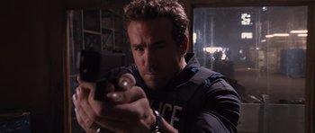 Movie still from “R.I.P.D.” (2013), directed by Robert Schwentke – A man in a police uniform holding a gun in a room; Close Up shot, Low angle