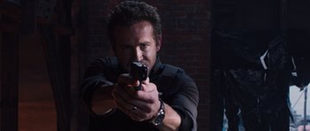 Movie still from “R.I.P.D.” (2013), directed by Robert Schwentke – A man is holding a gun in a dark room; Close Up shot, Low angle