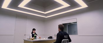 Movie still from “R.I.P.D.” (2013), directed by Robert Schwentke – Two people sitting at a table in a room; Wide shot, Low angle