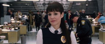 Movie still from “R.I.P.D.” (2013), directed by Robert Schwentke – A woman in a police uniform with a badge on her chest; Close Up shot, Over the shoulder angle