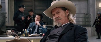 Movie still from “R.I.P.D.” (2013), directed by Robert Schwentke – A man in a cowboy hat sitting in front of another man; Medium shot, Over the shoulder angle