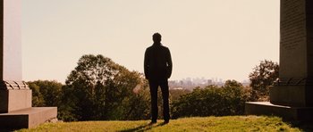 Movie still from “R.I.P.D.” (2013), directed by Robert Schwentke – A man standing on top of a grass covered hill; Extreme Wide shot, Low angle