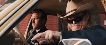 Movie still from “R.I.P.D.” (2013), directed by Robert Schwentke – A man in a cowboy hat and a man in a suit in the back of a car; Close Up shot, Over the shoulder angle