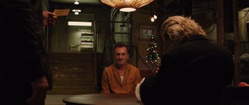 Movie still from “R.I.P.D.” (2013), directed by Robert Schwentke – A man sitting at a table in front of a christmas tree; Medium shot, Over the shoulder angle