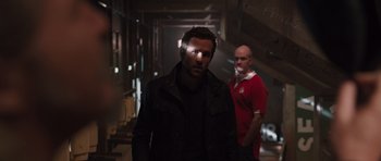 Movie still from “R.I.P.D.” (2013), directed by Robert Schwentke – A man standing next to another man in a dark room; Medium shot, Over the shoulder angle