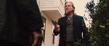 Movie still from “R.I.P.D.” (2013), directed by Robert Schwentke – A man in a suit and tie holding a gun; Medium shot, Over the shoulder angle