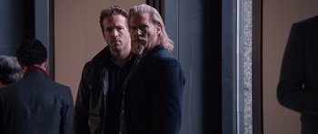 Movie still from “R.I.P.D.” (2013), directed by Robert Schwentke – A man with long hair stands next to a man with long hair; Medium shot, Over the shoulder angle