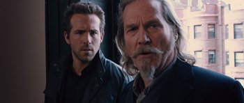 Movie still from “R.I.P.D.” (2013), directed by Robert Schwentke – A man with a beard is standing next to a man with short hair; Close Up shot, Over the shoulder angle