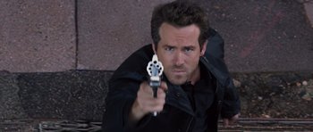 Movie still from “R.I.P.D.” (2013), directed by Robert Schwentke – A man is holding a gun in his hand; Close Up shot, High angle