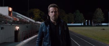 Movie still from “R.I.P.D.” (2013), directed by Robert Schwentke – A man in black jacket standing on a track; Close Up shot, Over the shoulder angle