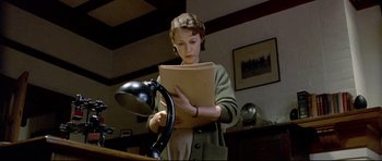 Movie still from “Rabbit-Proof Fence” (2002), directed by Phillip Noyce – A young girl reading a book in a room; Medium shot, Low angle