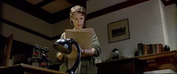 Movie still from “Rabbit-Proof Fence” (2002), directed by Phillip Noyce – A young woman holding a book and a lamp; Medium shot, Low angle