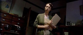 Movie still from “Rabbit-Proof Fence” (2002), directed by Phillip Noyce – A woman holding a piece of paper while standing in a room; Medium shot, Low angle