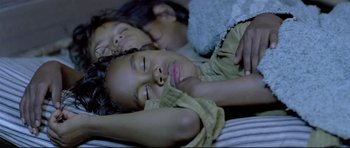 Movie still from “Rabbit-Proof Fence” (2002), directed by Phillip Noyce – Two young children laying on a bed and one of them is smiling; Extreme Close Up shot, Overhead angle