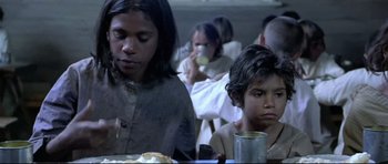 Movie still from “Rabbit-Proof Fence” (2002), directed by Phillip Noyce – A group of people sitting at a table eating food; Close Up shot, High angle