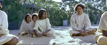 Movie still from “Rabbit-Proof Fence” (2002), directed by Phillip Noyce – A group of children sitting on the ground; Medium shot, High angle