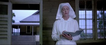 Movie still from “Rabbit-Proof Fence” (2002), directed by Phillip Noyce – A woman dressed as a nun writing on a notepad; Medium shot, Low angle