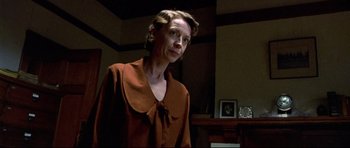 Movie still from “Rabbit-Proof Fence” (2002), directed by Phillip Noyce – A woman wearing a brown shirt standing in a room; Medium shot, Low angle