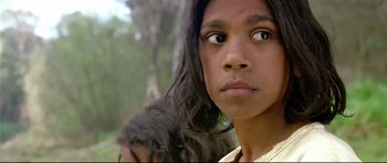 Movie still from “Rabbit-Proof Fence” (2002), directed by Phillip Noyce – A person with a dog on a field; Close Up shot, High angle