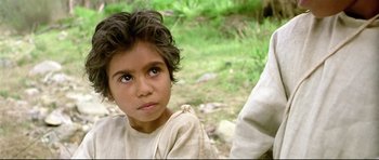 Movie still from “Rabbit-Proof Fence” (2002), directed by Phillip Noyce – A little girl with blue eyes sitting on the ground; Close Up shot, High angle